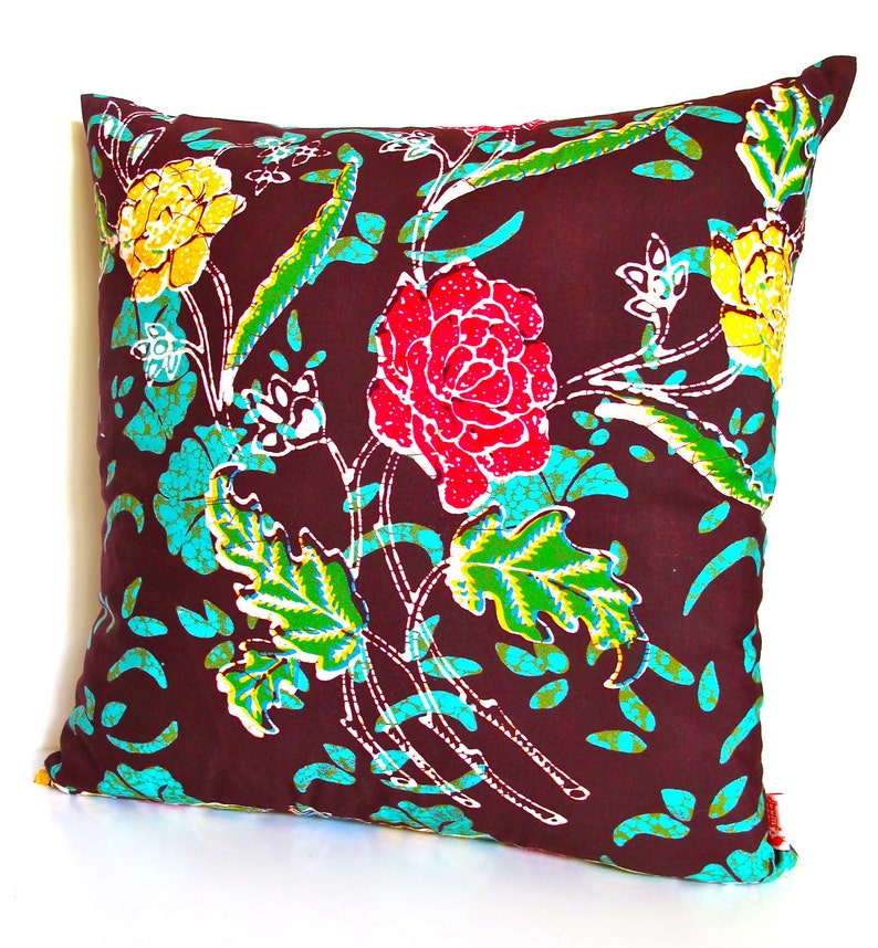 May include: A brown throw pillow with a floral pattern featuring red, yellow, and green flowers on a brown background.