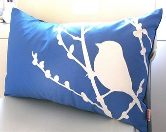 Coussin oiseau bleu royal sur fleur de cerisier