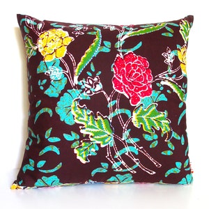 May include: A brown throw pillow with a floral pattern featuring pink, yellow, and green flowers on a brown background.