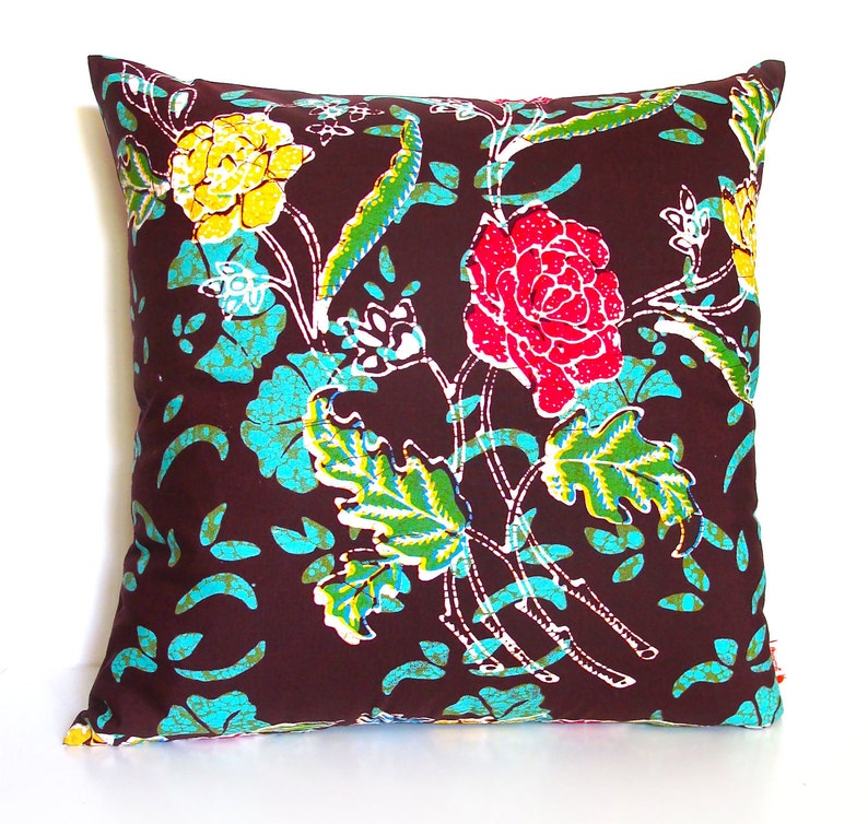 May include: A brown throw pillow with a floral pattern featuring pink, yellow, and green flowers on a brown background.