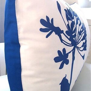 May include: White pillow with a blue floral design. The pillow has a blue border.
