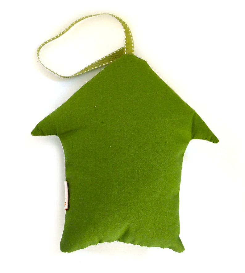 May include: A green fabric house-shaped pillow with a white dotted green ribbon loop for hanging.