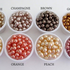 Puede incluir: Un surtido de cuentas de perlas en varios colores, incluyendo champ&aacute;n dorado, champ&aacute;n, marr&oacute;n, oro, amarillo, naranja, melocot&oacute;n y guayaba. Cada color se muestra en un peque&ntilde;o recipiente blanco con su nombre.
