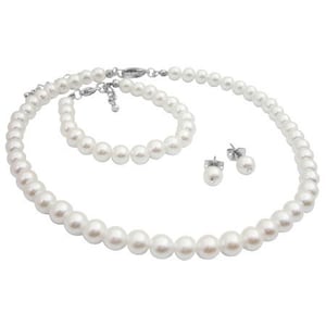 Puede incluir: Un conjunto de joyas de perlas blancas que incluye un collar, una pulsera y pendientes de bot&oacute;n. El collar y la pulsera presentan una hebra de perlas blancas redondas. Los pendientes tienen una sola perla en un poste plateado. El conjunto est&aacute; sobre fondo blanco.