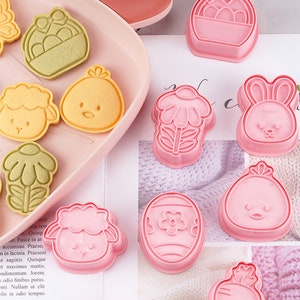May include: A set of ten pink plastic cookie cutters shaped like Easter-themed objects, including a bunny, a chick, a basket of eggs, a flower, a carrot, a butterfly, and a lamb.