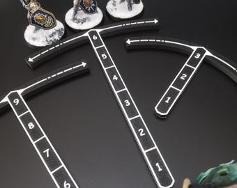 Könnte beinhalten: Miniaturfiguren gepanzerter Krieger mit Hämmern und Schilden, auf schneebedeckten Sockeln, sind in der Nähe von schwarz-weißen Messwerkzeugen positioniert. Die Werkzeuge haben nummerierte Markierungen, und die Szene spielt sich vor einem dunklen Hintergrund ab, was auf ein Tabletop-Spiel hindeutet.
