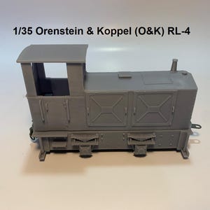 May include: A gray model of an O&K RL-4 locomotive. The model has a detailed design with a cab, doors, and various mechanical features. The text "1/35 Orenstein & Koppel (O&K) RL-4" is printed above the model.