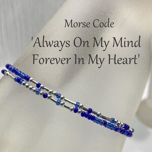 May include: A blue and silver beaded bracelet with the text 'Morse Code 'Always On My Mind Forever In My Heart' and the website 'LoveThemBeads.etsy.com'.