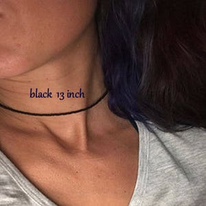May include: A black choker necklace on a person's neck. The text "black 13 inch" is written on the image.