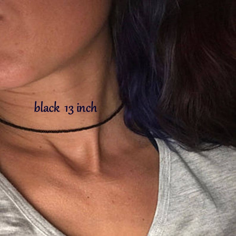 May include: A black choker necklace on a person's neck. The text "black 13 inch" is written on the image.