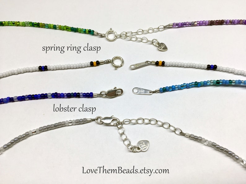 May include: Four beaded necklaces with different colored beads and clasps. The top two necklaces have spring ring clasps, and the bottom two necklaces have lobster clasps. The text "LoveThemBeads.etsy.com" is visible at the bottom of the image.