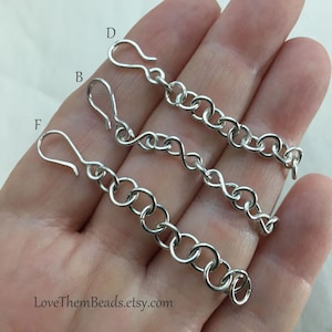 May include: Three silver chain extenders with lobster clasps. The chains are labeled with the letters B, D, and F.