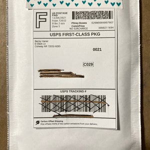 May include: White envelope with a USPS First-Class Package label. The label includes the sender's name, address, and the recipient's name and address. The label also includes the tracking number, postage paid information, and the date of mailing. The envelope has a green leaf icon with the text "Carbon-Offset Shipping" and "Etsy offsets 100% of the carbon emissions from your delivery."