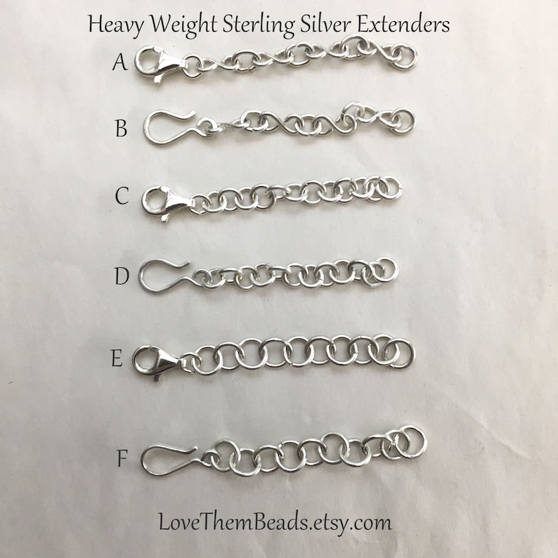 May include: Six sterling silver chain extenders labeled A through F. The extenders are arranged vertically, with the shortest at the top and the longest at the bottom. Each extender has a lobster clasp at one end and a jump ring at the other.