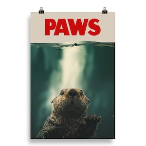 May include: A poster with the word "PAWS" in red letters at the top. The poster features a close-up of a sea otter's head and shoulders, looking up at the viewer. The otter is in the water, and the surface of the water is visible at the top of the image.