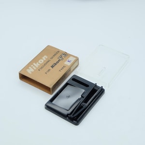 May include: A set of three ceramic mugs with a speckled, matte finish. The mugs are in shades of cream, light brown, and dark brown. Each mug has a simple, minimalist design, perfect for coffee or tea.