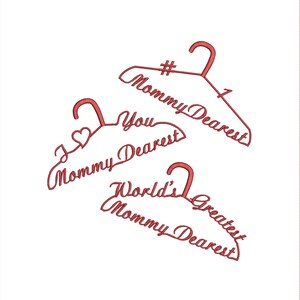 May include: Three pink wire hangers with the text "#1 Mommy Dearest", "You Mommy Dearest", and "World's Greatest Mommy Dearest" written on them.