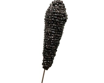 May include: A black beaded corn stalk on a wire stem. The beads are small and tightly packed, creating a realistic corncob look.