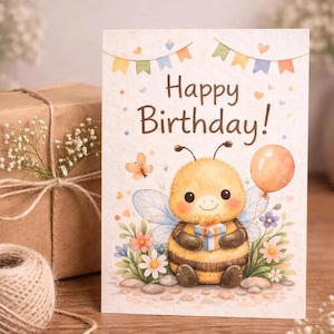 Puede incluir: Tarjeta de cumpleaños con una ilustración en acuarela de una abeja de dibujos animados sosteniendo un regalo y un globo. La tarjeta dice "Happy Birthday!" y está decorada con flores y una pancarta.