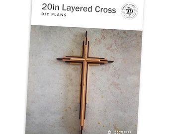 May include: DIY plans for a 20-inch layered wooden cross. The cross is made of multiple layers of wood, creating a unique and modern design. The cross is shown against a light gray background.
