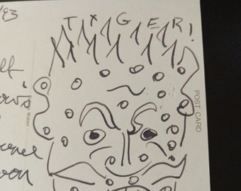 May include: A black and white line drawing of a face with a large mouth and teeth. The face has a lot of small circles around it. The text "Tiger!" is written above the face.
