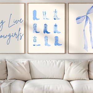 May include: Three framed prints with a blue and white color scheme. The left print features the text "Long Live Cowgirls" in blue cursive script. The center print features nine blue cowboy boots. The right print features a large blue bow.