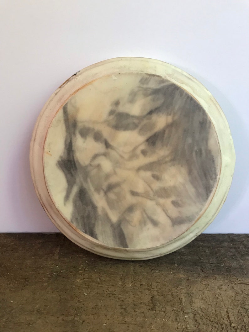 Puede incluir: Bandeja redonda de color crema con un dise&ntilde;o veteado gris y blanco. La bandeja tiene un borde elevado y un acabado liso y brillante. El dise&ntilde;o recuerda a la piedra natural, a&ntilde;adiendo un toque de elegancia a cualquier espacio. Mide unos 20 cm de di&aacute;metro.