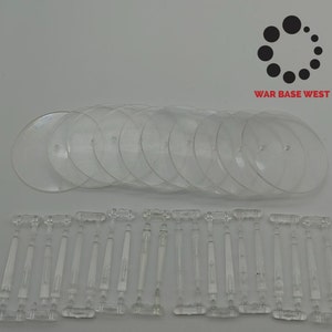 May include: A set of 10 clear plastic round bases and 20 clear plastic rods. The bases are approximately 2 inches in diameter. The rods are approximately 2 inches long.