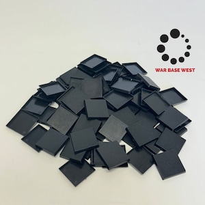 May include: A pile of black square plastic bases for miniature figures. The bases are approximately 2.5 cm square.  WAR BASE WEST is printed on the image.