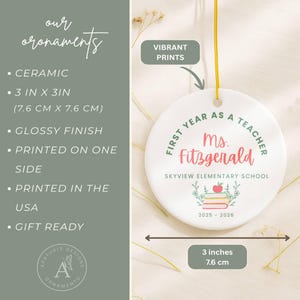 K&ouml;nnte beinhalten: Keramik-Ornament, 7,6 cm x 7,6 cm, mit gl&auml;nzendem Finish. Das Ornament zeigt den Text "First Year as a Teacher Ms. Fitzgerald" und "Skyview Elementary School". Enth&auml;lt einen Stapel B&uuml;cher und einen Apfel.