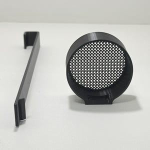 May include: Black 3D-printed kitchen accessory set. Includes a cylindrical strainer with a mesh interior and a flat, rectangular handle. The items are made of black plastic and are set against a white background.