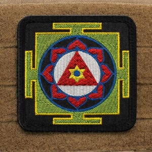 May include: A white ceramic mug with a black handle and the text "But First, Coffee" in a black, handwritten-style font. The mug is on a white surface.