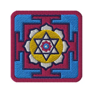 May include: A red, blue, and white embroidered patch with a six-pointed star in the center. The star is surrounded by a yellow circle and a white flower.