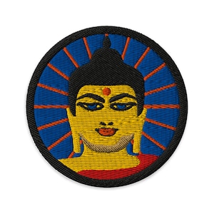 May include: Embroidered patch featuring a yellow Buddha face with a red dot on the forehead, surrounded by a blue and orange mandala design.