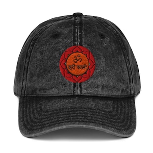 May include: A black vintage washed denim baseball cap with an embroidered red and orange mandala featuring the Om symbol and the text "Kutri Kali".