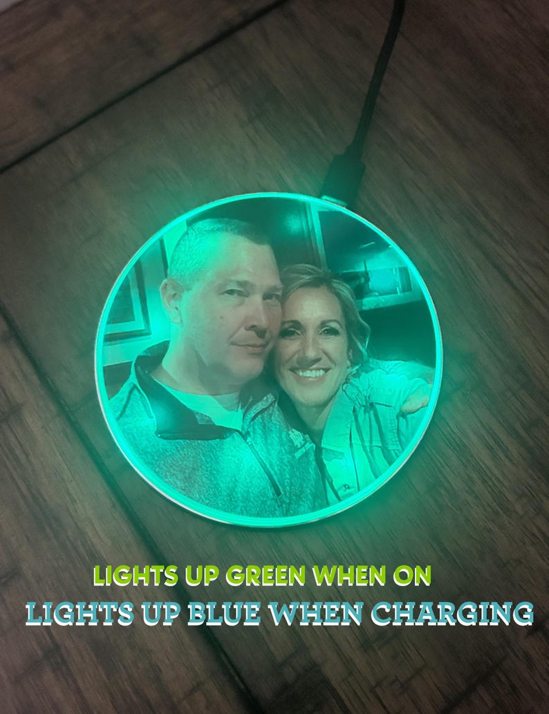 May include: A round wireless charging pad with a photo of a couple printed on it. The charging pad lights up green when on and blue when charging.