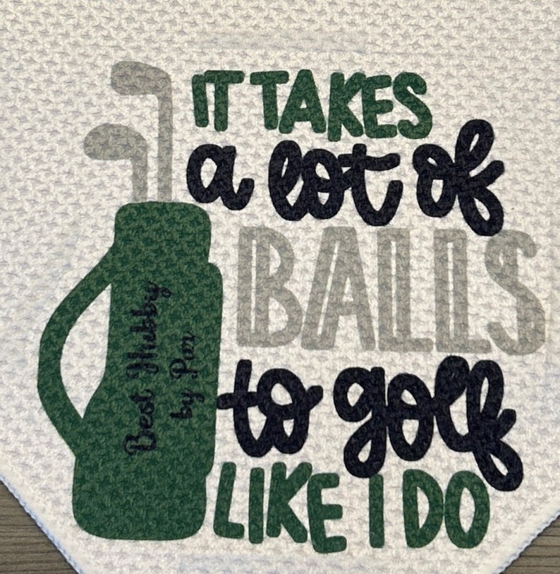 May include: White golf towel with the text "IT TAKES a lot of BALLS to golf LIKE I DO". The towel features a green golf bag with golf clubs and the text "Best Hubby by Pam".