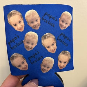 May include: Blue can cooler with multiple photos of children's faces and the text "papa's besties" repeated around the images.