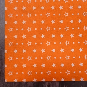 May include: Orange felt fabric with a white star pattern.