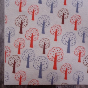 May include: A white fabric with a repeating pattern of stylized trees in red, blue, and brown. The trees have a dotted pattern.