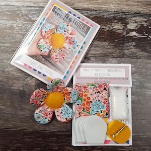 Peut inclure: Un kit de broche fleur avec tissu, pétales de feutre, cercles de feutre et une barre de broche. Le kit comprend une broche fleur finie avec un centre jaune et des pétales à motifs floraux. L'emballage indique "Flower Brooch" et "Paper-and-String".
