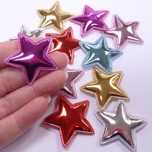 Può includere: Assortimento di 10 decorazioni metalliche a forma di stella in vari colori, tra cui oro, argento, rosso, rosa, blu e azzurro. Ogni stella ha un design in rilievo 3D e una finitura lucida e riflettente.