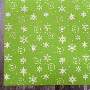 May include: Green felt sheet with a white snowflake and swirl pattern.