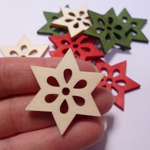 Peut inclure: Une collection d'étoiles en bois avec des motifs découpés complexes. Les étoiles sont dans des tons de rouge, de vert et de bois naturel.