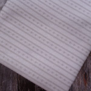 May include: White fabric with a subtle, repeating pattern of small, gray floral sprigs. The fabric has a striped design with the floral pattern running along each stripe.