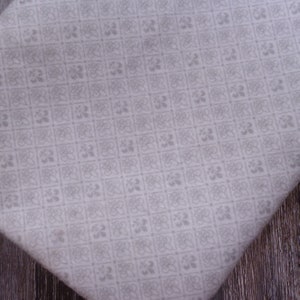 May include: White fabric with a repeating pattern of small gray squares containing a floral design.