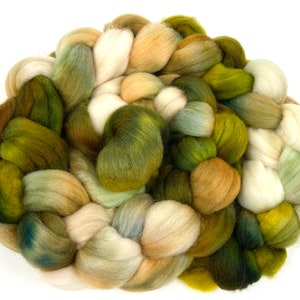 May include: A braided bundle of wool yarn in shades of green, beige, and white. The yarn is soft and fluffy, and it would be perfect for knitting or crocheting.