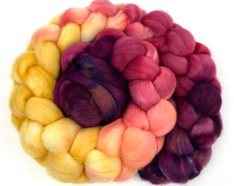 May include: A braided bundle of wool yarn in shades of yellow, orange, pink, and purple.