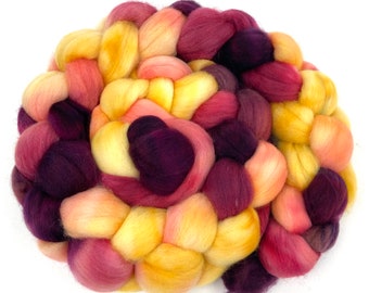 May include: A braided bundle of wool yarn in shades of yellow, orange, pink, and purple.