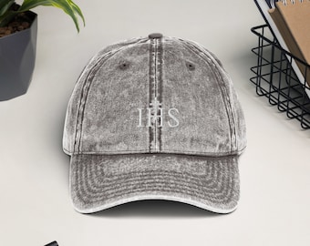May include: A gray distressed denim baseball cap with a white embroidered "IHS" symbol.